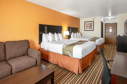 um quarto de hotel com duas camas e um sofá em Quality Inn Dodge City em Dodge City