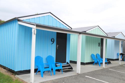 a group of blue chairs sitting on a building at Kaiteriteri Reserve Cabins in Kaiteriteri