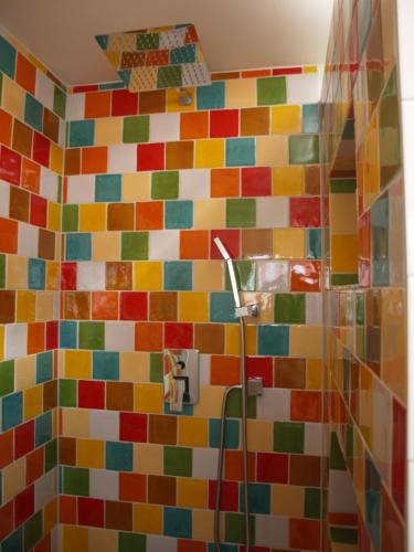 Baño con azulejos de colores en la pared en JaBaKi Child friendly home, en Hoofddorp