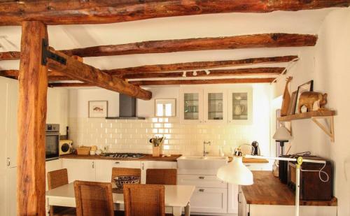 a kitchen with wooden beams and a table and chairs at Cal cabironet in Masdenverge