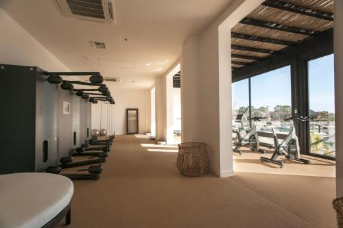 une salle de sport avec une rangée de tapis de course et d'équipements d'exercice dans l'établissement Hotel El Ganzo Adults Only, à San José del Cabo