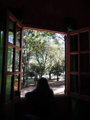 a person is looking out of a window at Cabañas Oberá in Oberá