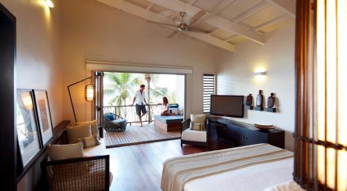 a bedroom with a bed and a person walking out of the door at Tadrai Island Resort in Mana Island