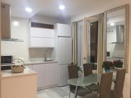 a kitchen with a table and a white refrigerator at Apartamento Calle Nueva in Cádiz