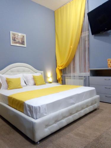 een slaapkamer met een groot bed en een geel gordijn bij Near Rynok Square in Lviv