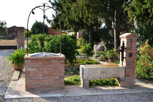 a fountain in a park with a stone bench at B&B Arcadia in Gualtieri