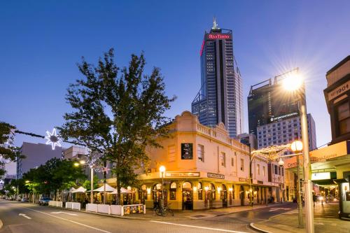 una calle de la ciudad por la noche con edificios altos en Nightcap at Belgian Beer Cafe en Perth