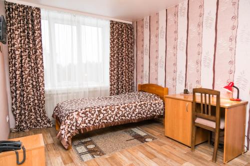 ノヴォシビルスクにあるZolotaya dolina - Akademgorodokのベッドルーム1室(ベッド1台、デスク、窓付)