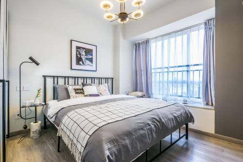 a bedroom with a bed and a large window at Chengdu Jinniu District North City No. 8 Locals Apartment 00169850 in Chengdu
