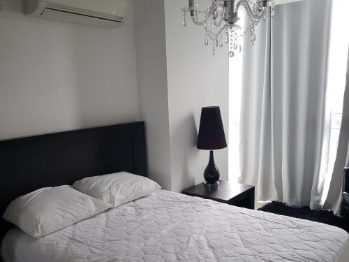 um quarto com uma cama, um candeeiro e uma janela em Ibiza Playa Corona em Chame