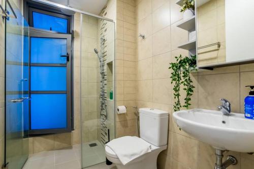a bathroom with a toilet and a sink and a shower at The Robertson Residences in Kuala Lumpur