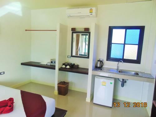 a room with a sink and a bed and a mirror at Lanta Amara Resort in Ko Lanta