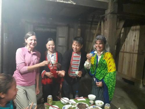 a group of people standing around a table with food at Dao Homestay in Hoàng Su Phì