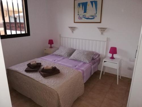 ein Schlafzimmer mit einem Bett mit zwei Hüten darauf in der Unterkunft Dunasol in Corralejo