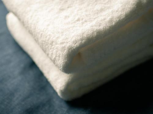a close up of a white towel on a bed at the square hotel GINZA in Tokyo