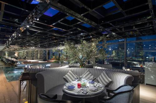a restaurant with a table and chairs and a bar at New Orient Hotel Da Nang in Da Nang
