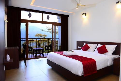 a bedroom with a large bed and a balcony at Palmtree Leaf, Munnar in Munnar