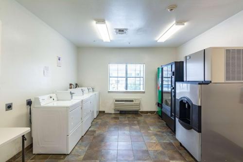 a large kitchen with white cabinets and a refrigerator at Motel 6-Winnie, TX in Winnie