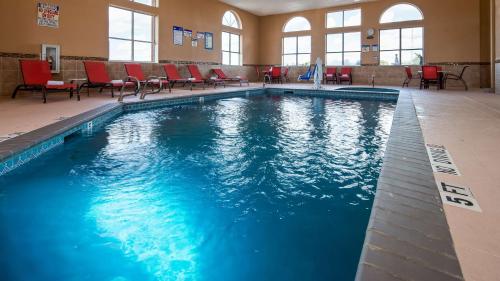 a large swimming pool with red chairs in a building at Best Windsor Inn in Lubbock