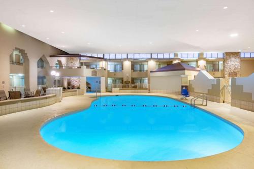 格蘭德島的住宿－Ramada by Wyndham Midtown Grand Island，酒店大堂中央的大型游泳池