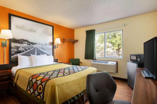 ein Hotelzimmer mit einem Bett und einem TV in der Unterkunft Super 8 by Wyndham Waco University Area in Waco