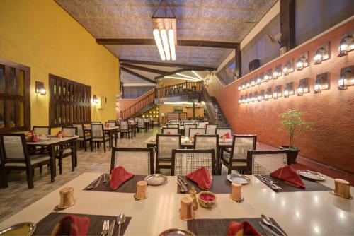 - un restaurant avec des tables et des chaises dans une salle dans l'établissement Goldfinch Hotel Bangalore, à Bangalore