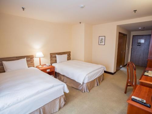 Postel nebo postele na pokoji v ubytování Jiuwu Hotel