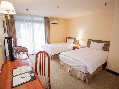 Postel nebo postele na pokoji v ubytování Jiuwu Hotel