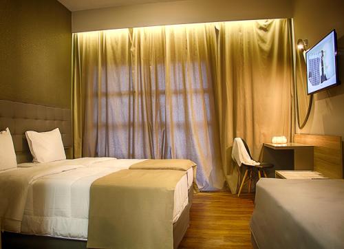 a hotel room with two beds and a window at Athlos Hotel in Thessaloniki