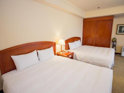 Postel nebo postele na pokoji v ubytování Jiuwu Hotel