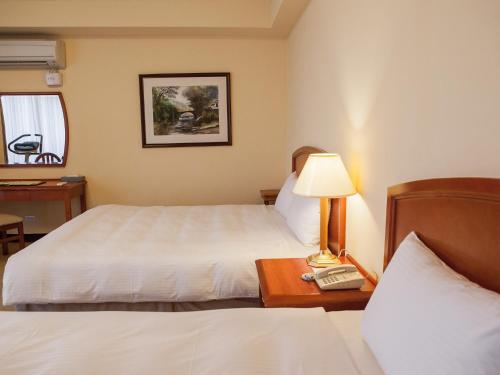Postel nebo postele na pokoji v ubytování Jiuwu Hotel
