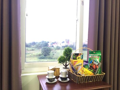 a table with a basket of food and drinks on a window at HD Hotel Nội Bài in Noi Bai