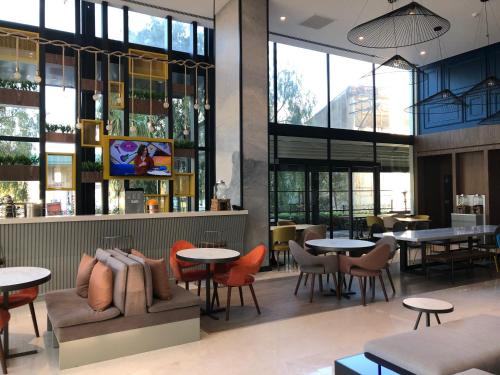 a restaurant with tables and chairs and windows at ibis Styles Izmir Bornova in Izmir