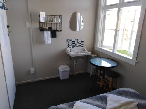 a bathroom with a sink and a mirror at Hokitika Pioneer Hotel in Hokitika