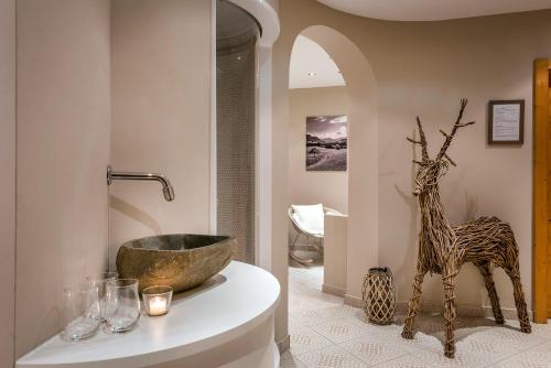 a bathroom with a tub and a statue of a giraffe at Landhaus Tanner in Waging am See