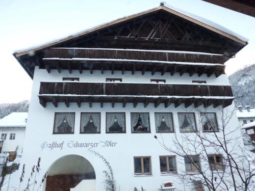 a building in the mountains with a sign that reads spiritual churer alpha at Hotel Schwarzer Adler in Pettneu am Arlberg