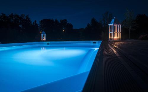 une piscine éclairée la nuit dans l'établissement Au pied du Lariat, à Léoville