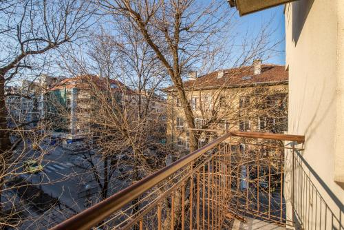een balkon van een gebouw met bomen en gebouwen bij Colorful Two Bedroom Apartment next to Serdika Center Sofia in Sofia
