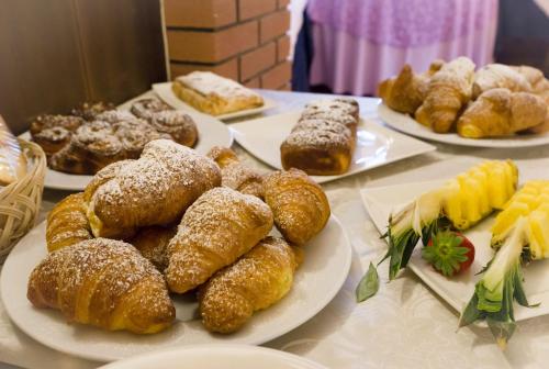 a table topped with plates of pastries and other desserts at Hotel Aurora in Cimego