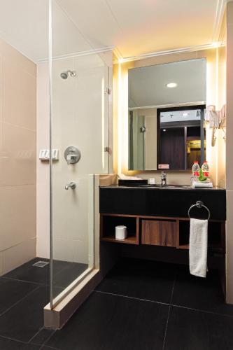 a bathroom with a sink and a mirror at Best Western Papilio Hotel in Surabaya