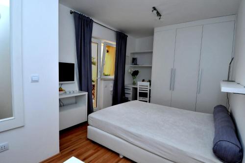 sypialnia z białym łóżkiem i telewizorem w obiekcie Apartments Annette w Dubrowniku