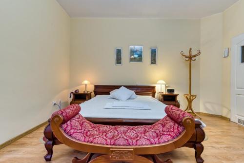 Hotel Gracja في جورزو فيلكوبولسكي: غرفة نوم بسرير وبطانية وردية