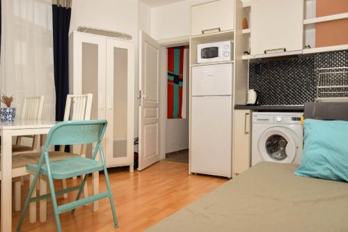 een klein appartement met een keuken, een tafel en een stoel bij Apartment Coral in Pomorie