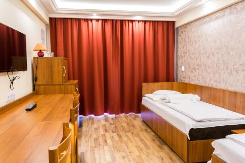a bedroom with a bed and a red curtain at BL.Apartmanház II. in Szeged