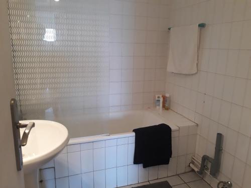 une salle de bain avec un lavabo et une baignoire et un lavabo dans l'établissement L'Acapulco, à La Grande Motte