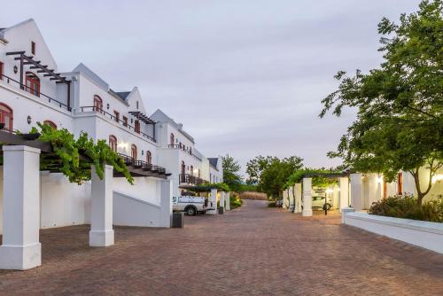 a street of white buildings with a driveway at De Zalze Lodge in Stellenbosch