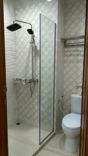a bathroom with a toilet and a glass shower door at Villa Rosvita Bandung in Lembang