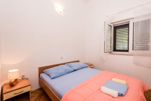 a small bedroom with a bed and a window at Villa Gloria in Potomje