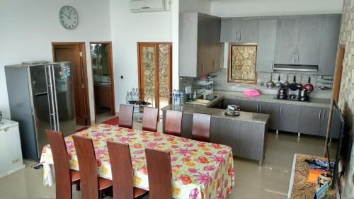 a kitchen with a table and a kitchen with a refrigerator at Villa Rosvita Bandung in Lembang