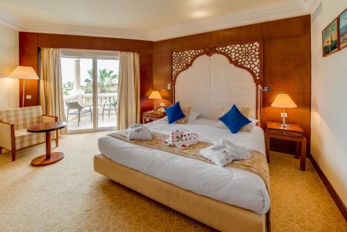 a hotel room with a large bed and a balcony at Le Royal Hammamet in Hammamet